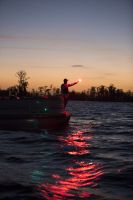 Using a handheld flare at dusk aboard a boat 16-21 feet.