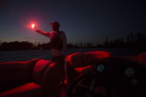 Using a handheld flare at dusk aboard a boat 16-21 feet.