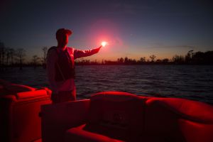 Using a handheld flare at dusk aboard a boat 16-21 feet.