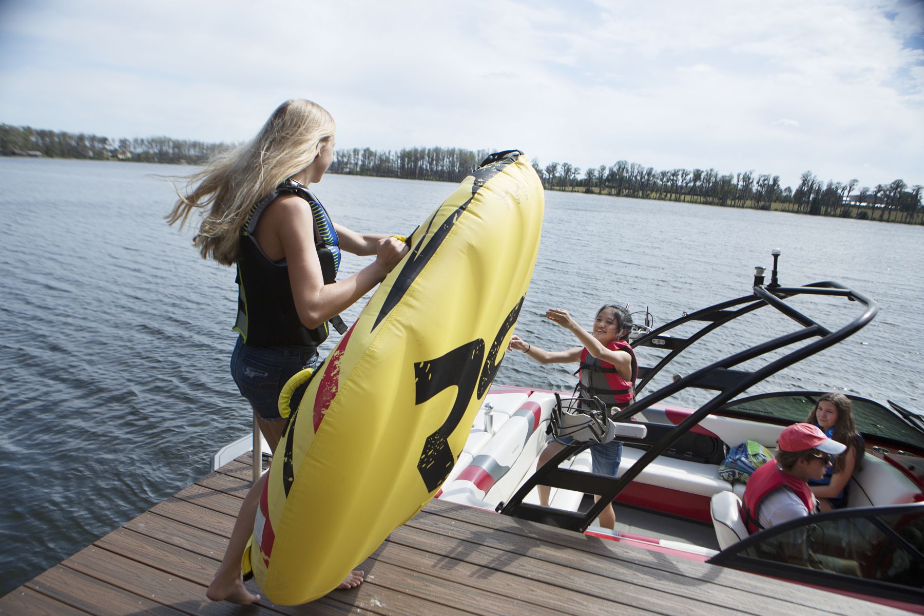 Kids loading the boat for a fun afternoon on the water in properly fitting life jackets.