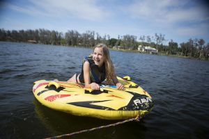 Kids having a fun afternoon on the water in properly fitting life jackets.