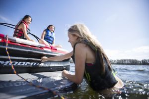 Kids having a fun afternoon on the water in properly fitting life jackets.