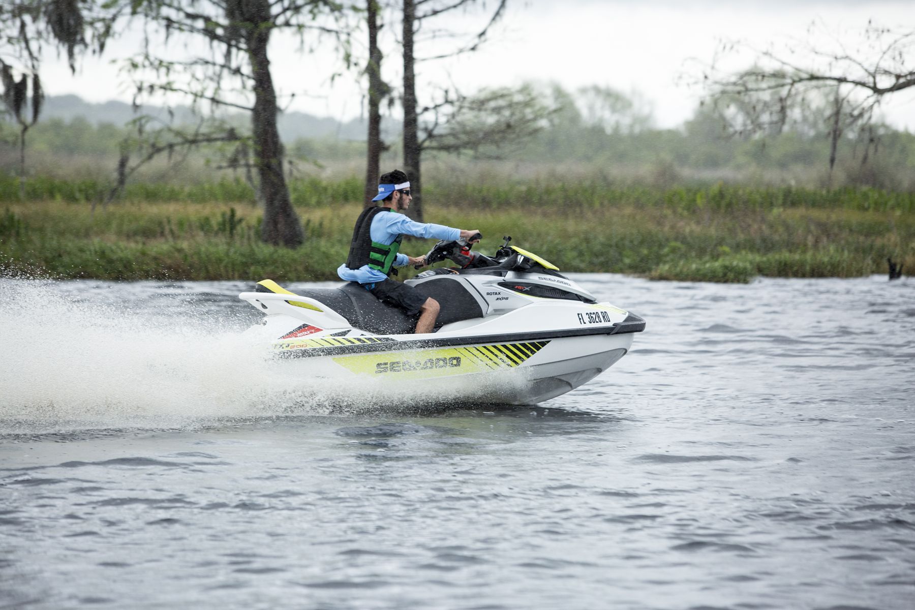 Riding a personal watercraft while wearing a properly fitting life jacket.
