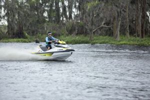 Riding a personal watercraft while wearing a properly fitting life jacket.