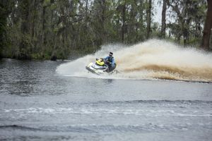 Riding a personal watercraft while wearing a properly fitting life jacket.