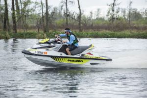 Riding a personal watercraft while wearing a properly fitting life jacket.