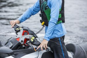 Using a safety lanyard kill switch on a personal watercraft while wearing a properly fitting life jacket.