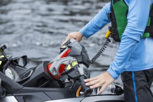 Using a safety lanyard kill switch on a personal watercraft while wearing a properly fitting life jacket.