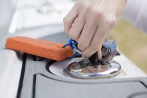 Opening a locked gas cap on a boat.