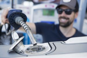 Inserting the nozzle in the fuel neck for refueling a boat at a land pump.